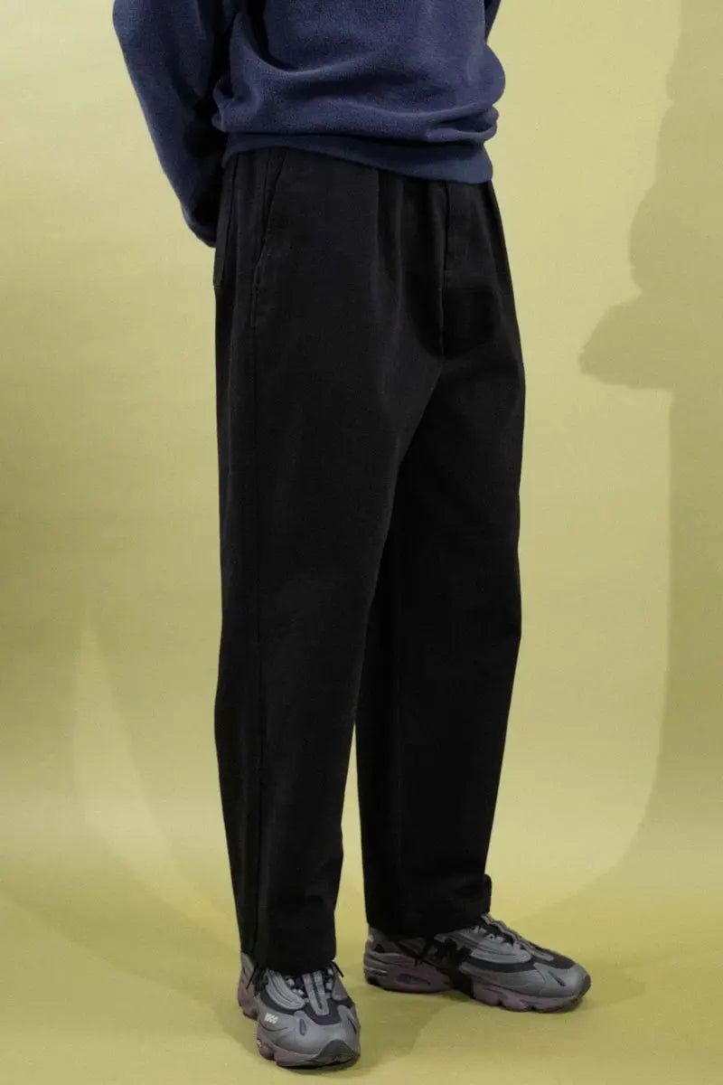 Pantalon Quasi Warren en tissu noir, style décontracté, visible avec détails de couture et coupe moderne, pour homme.