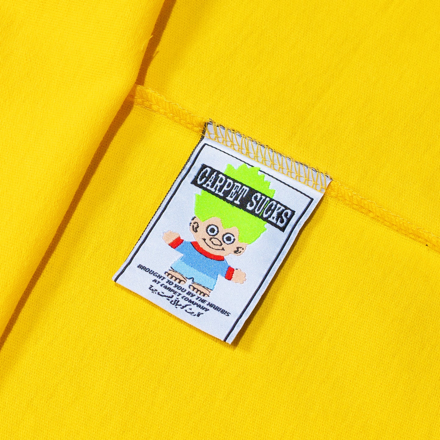 T-shirt jaune de la marque Carpet C.C. Sucks, tissu en coton avec logo imprimé sur la poitrine.